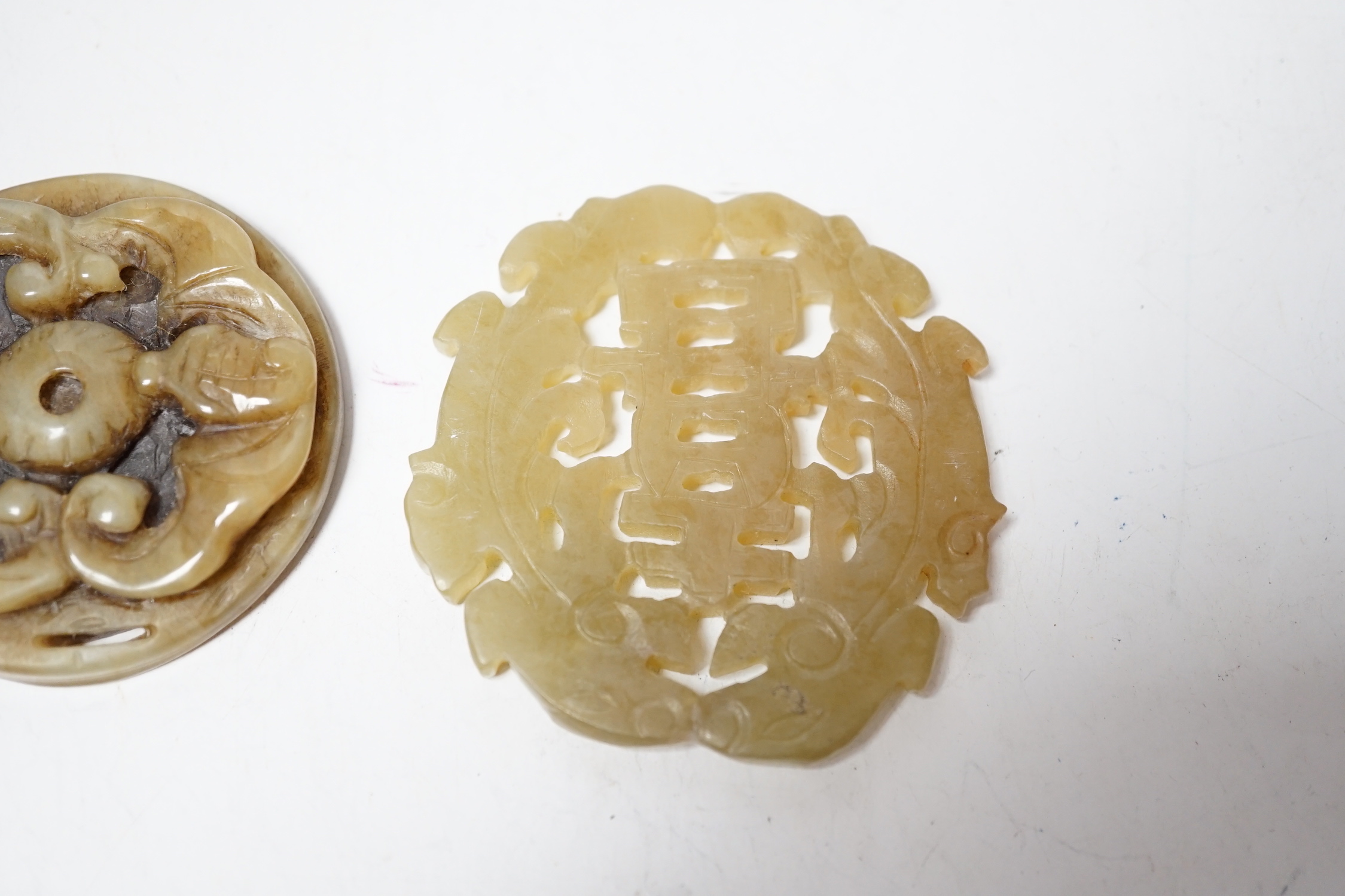 Two Chinese carved bowenite jade discs, largest 6cm diameter